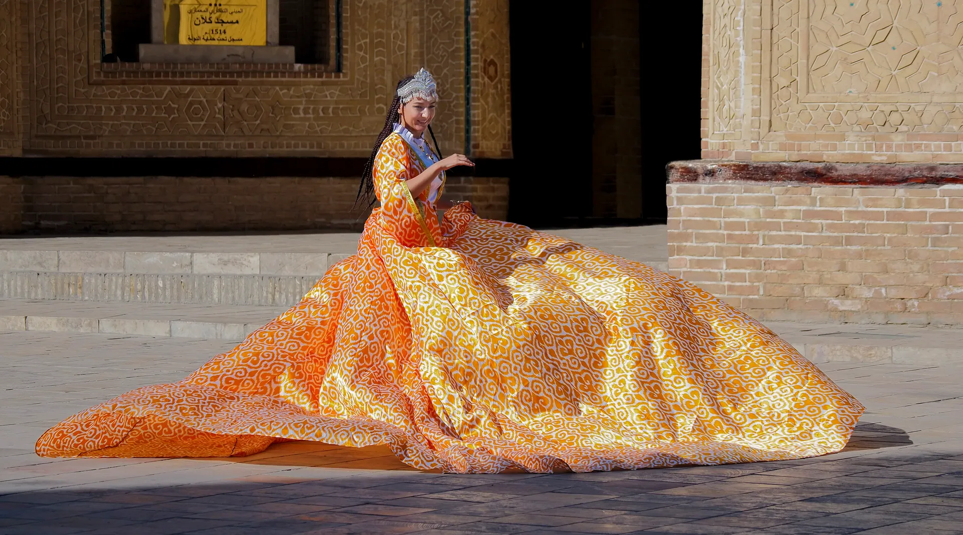 A long dress of adras — half silk, half cotton, woven with ikat patterns — spread out on the stones of the Po-i-Kalyan complex in Bukhara.