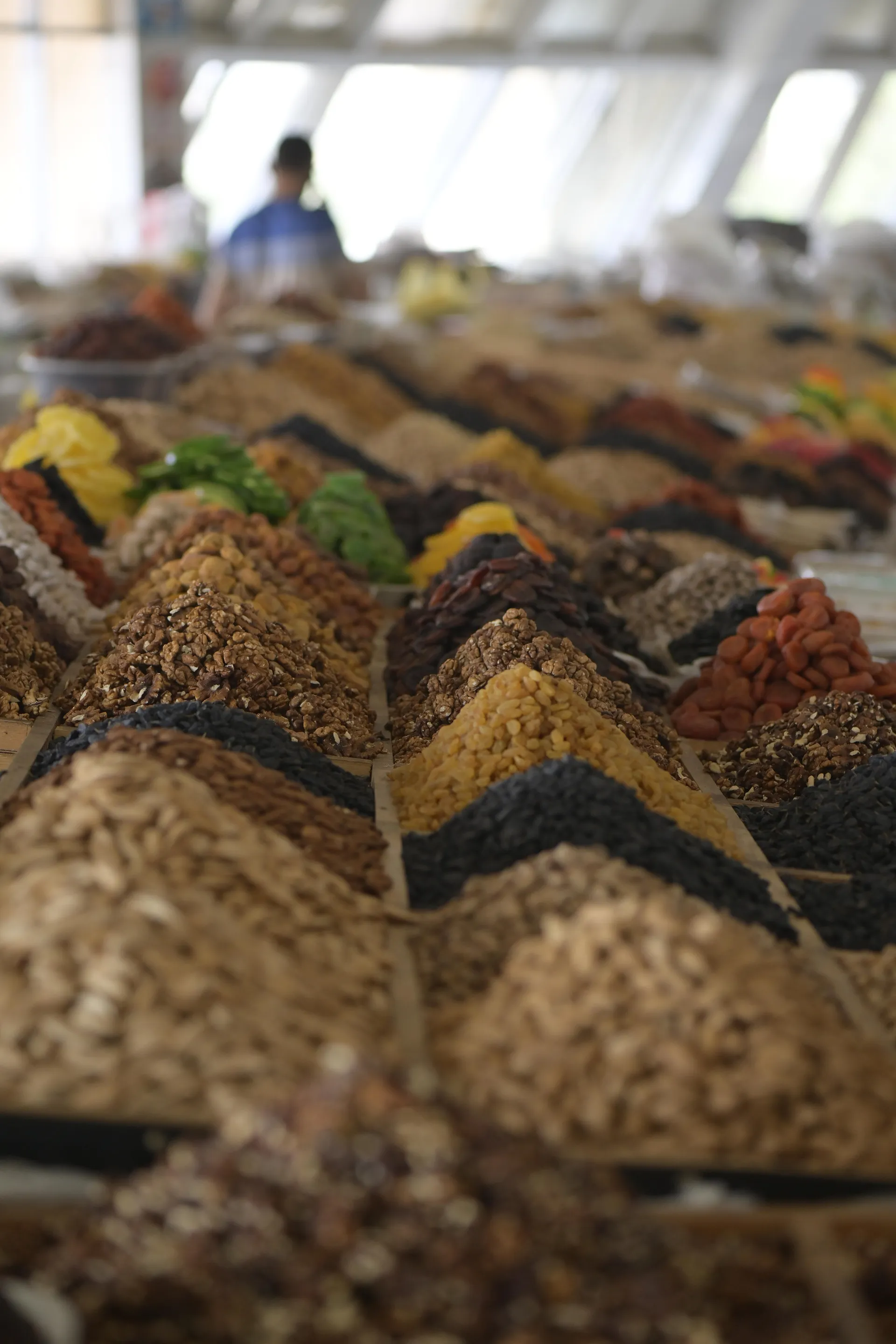 Apricots, raisins, almonds, pistachios and roasted apricot kernels heaped on a market stall — the snack of every Uzbek table.