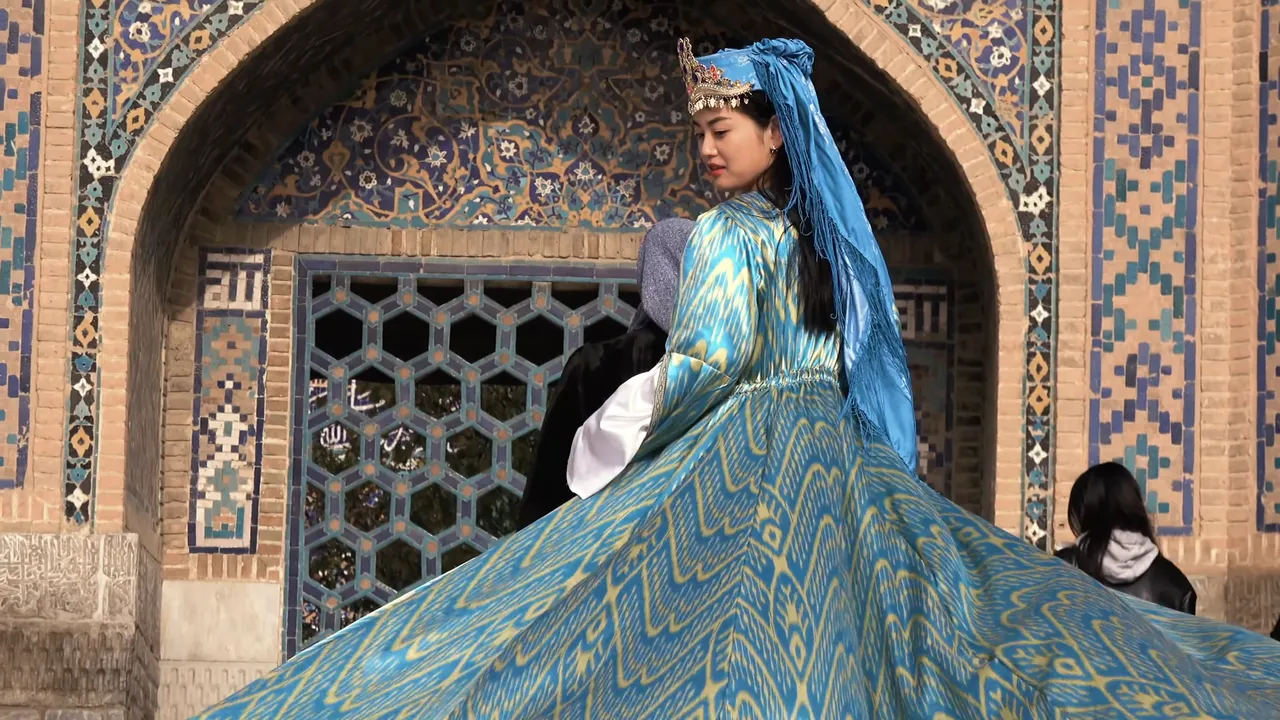 A dress of atlas — ikat silk, its pattern dyed into the threads before weaving — swirling in front of a tiled portal.