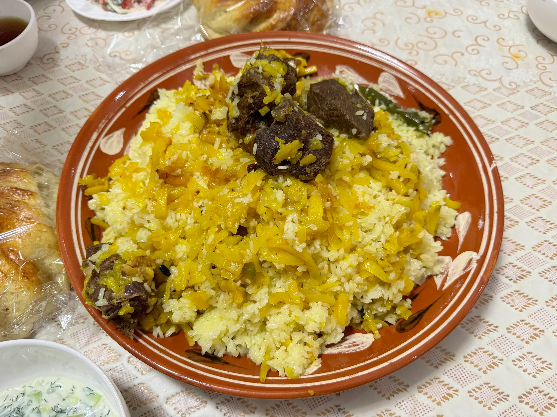 A family plov cooked in a Tashkent home: yellow carrots, chickpeas and lamb piled on top of the rice.