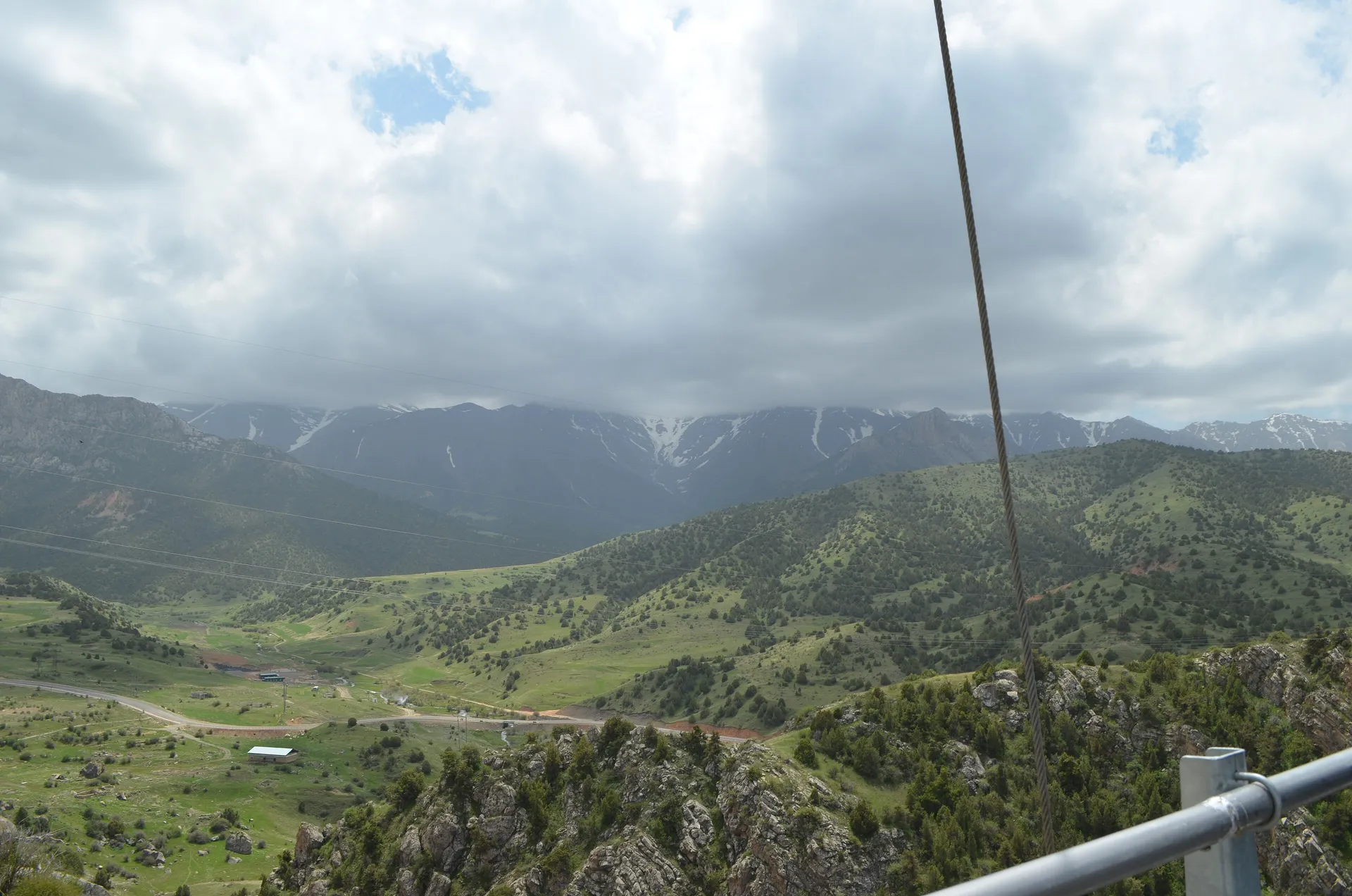 The view from the suspension bridge in Zaamin National Park, looking down a green valley in the mountains of Jizzakh region.